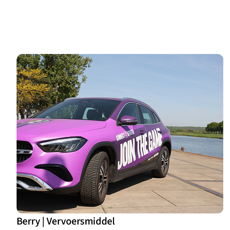 Paarse Connect2Sports-auto Berry met ‘Join the Game’-opdruk geparkeerd aan het water onder een blauwe hemel.